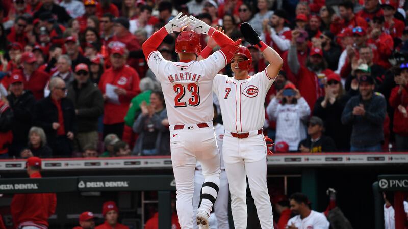 Nick Martini (23), de los Rojos de Cincinnati, recibe felicitaciones de Spencer Steer (7) tras...