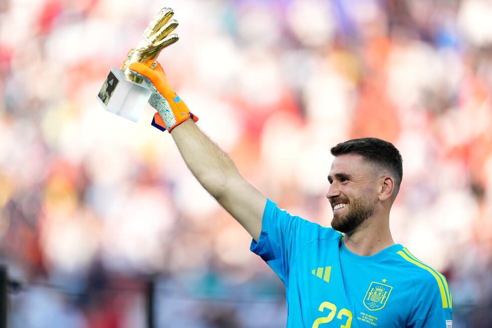 Spain goalkeeper Unai Simon poses with the tournament's best goalkeeper award at the end of...