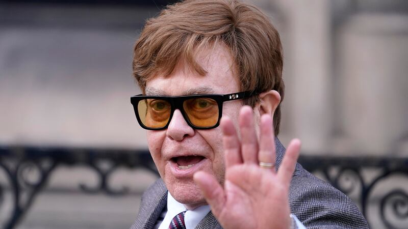 FILE - Elton John waves to the waiting media as he leaves the Royal Courts Of Justice in...